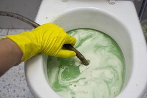 a plumber fixing a clogged toilet